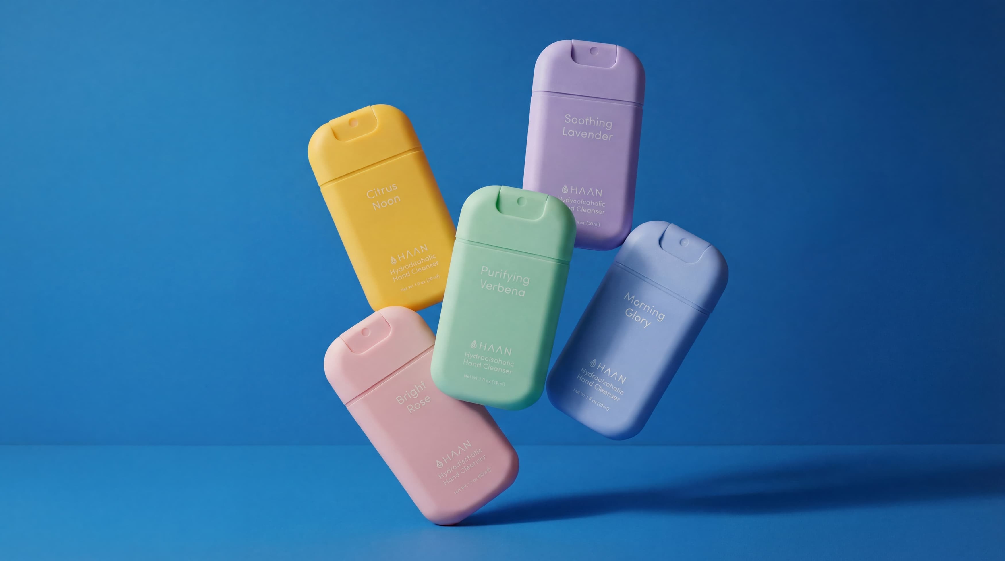 Five colorful small hand sanitizers on a blue background